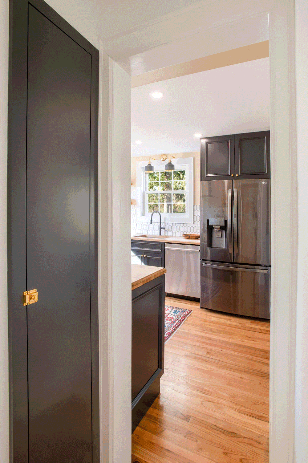 black pantry door outside kitchen