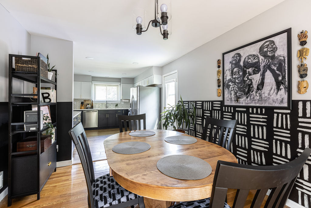 Dining area overlooking open kitchen with bookcase on wooden flooring after renovation