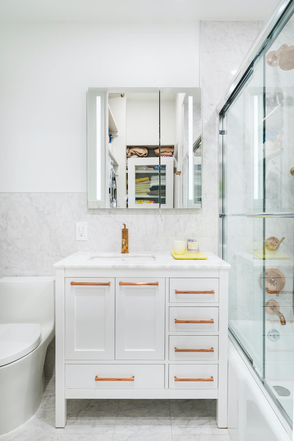White bathroom vanity with bronze hardware