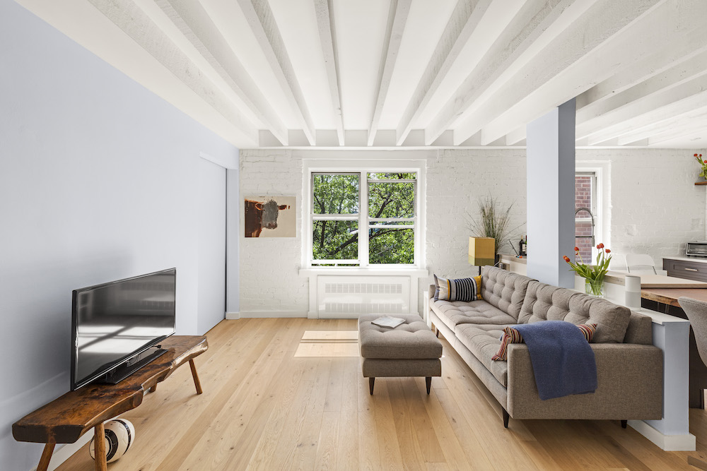 Apartment with hardwood flooring and ceiling beams