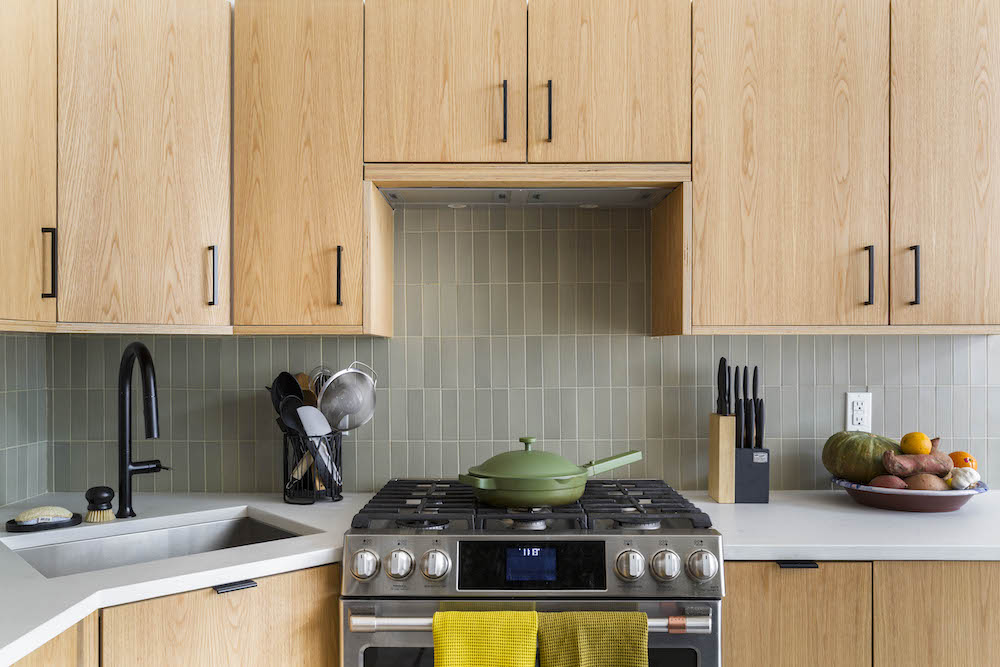 Stainless steel range and green tile backsplash