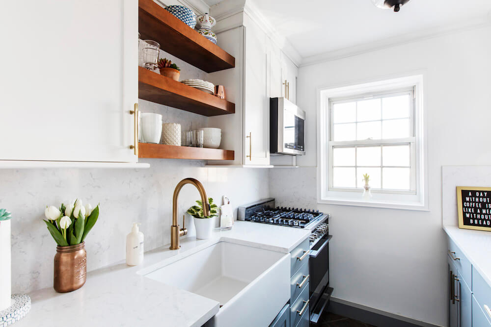 Kitchen with two-tone cabinets and marble counters