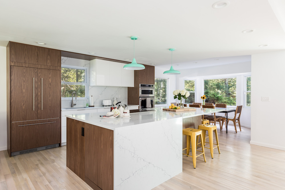White marble island with wood paneled kitchen