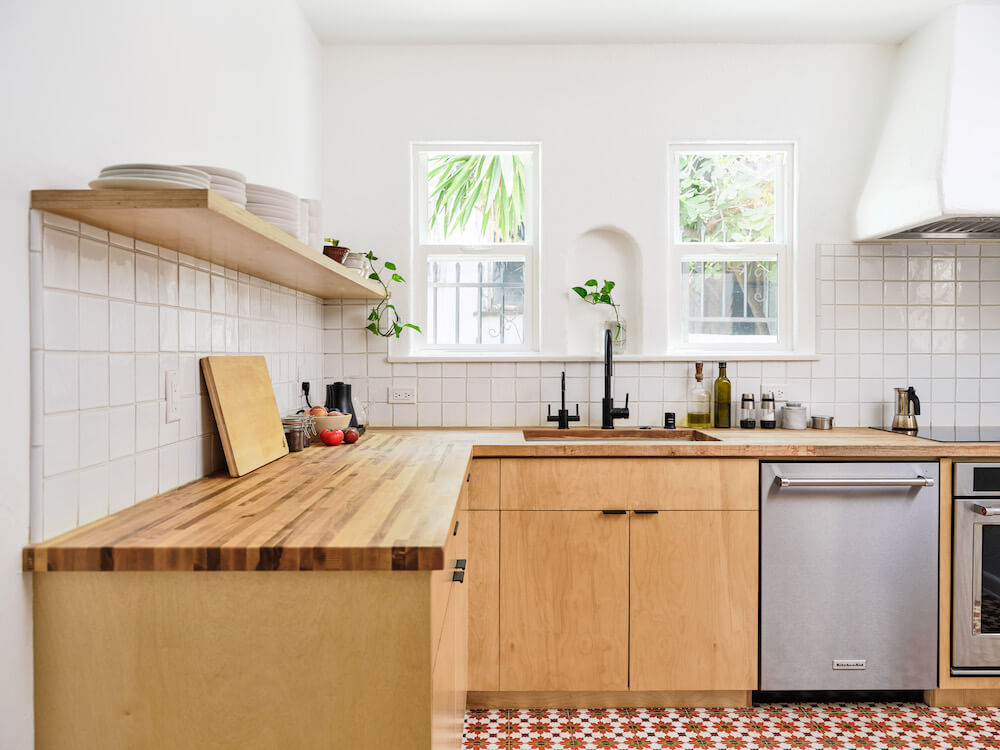 white country cottage kitchen with patterened floor tiles and butcher block countertop and golden oak cabinets after renovation