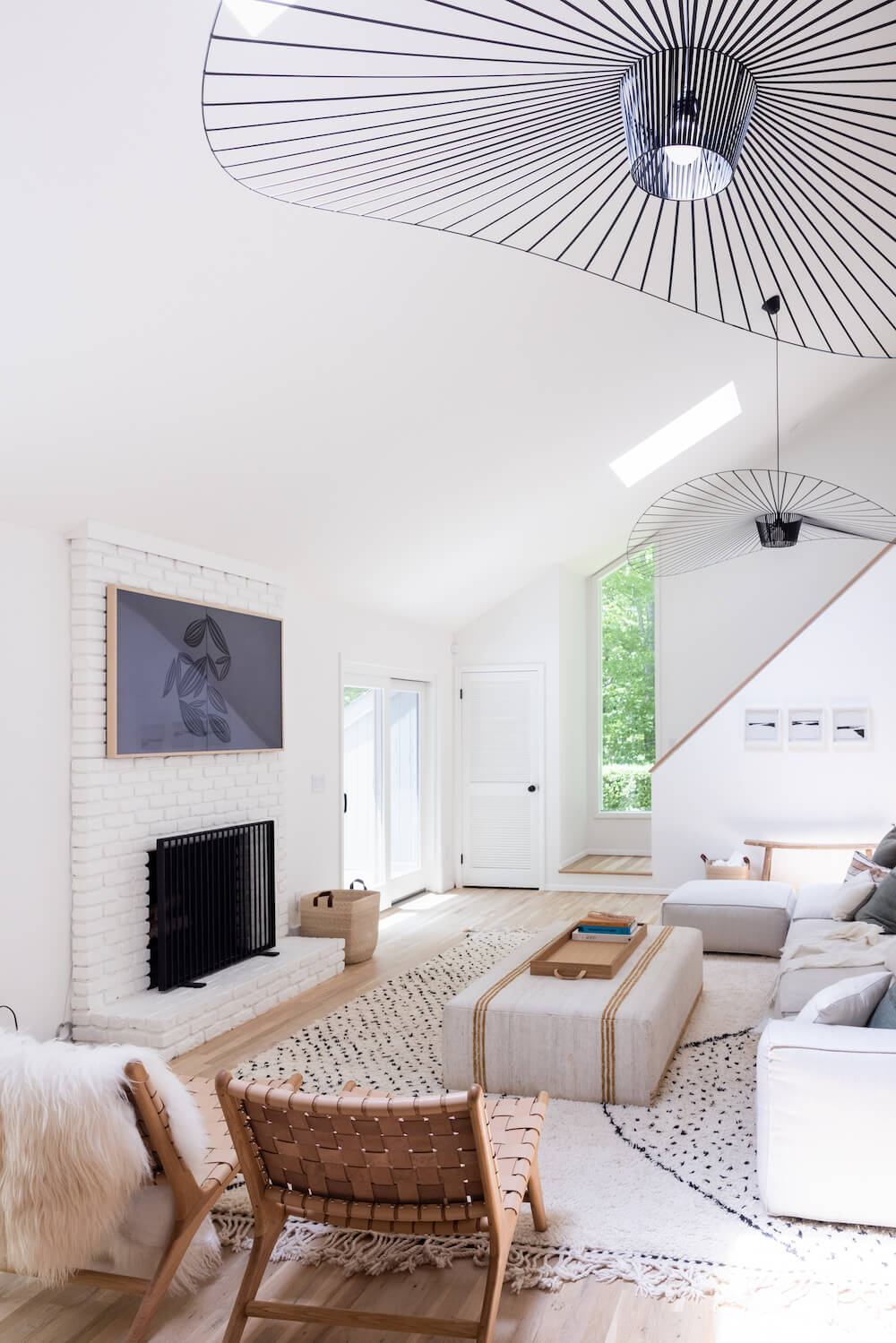 Living area with white fireplace and woven leather chairs