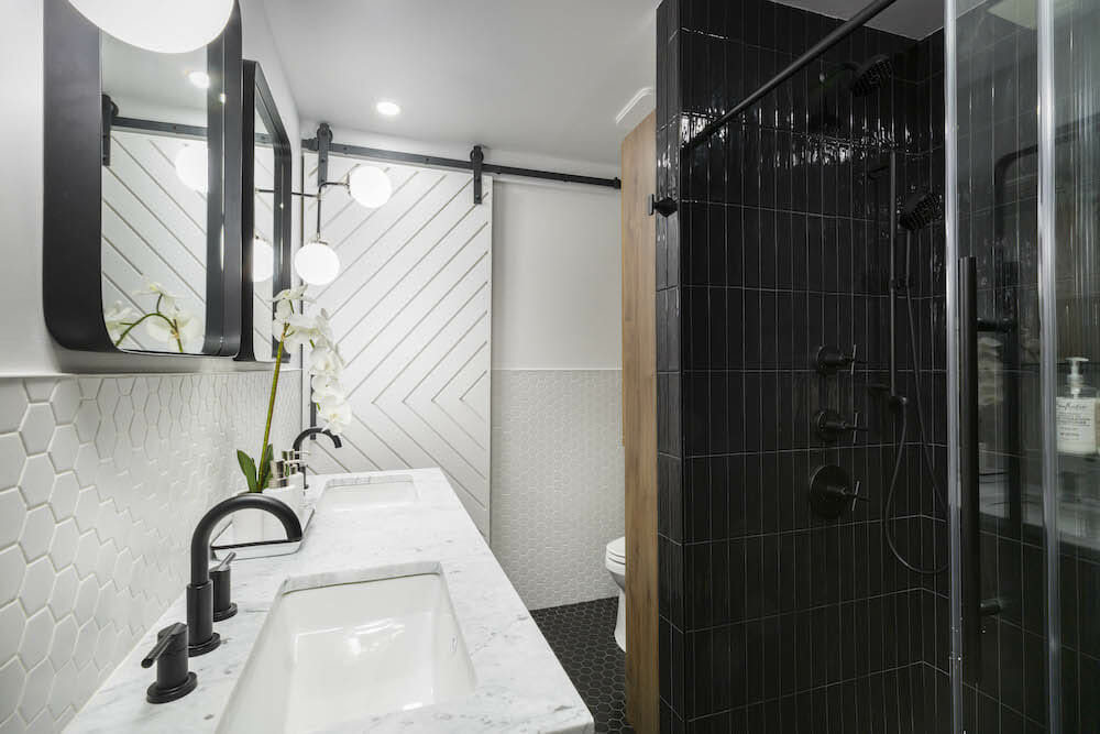 Double sink vanity with the view of the barn door and shower area after renovation