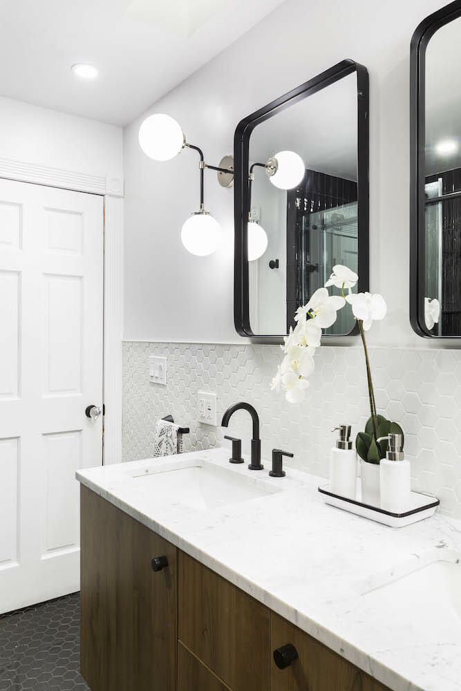 Large white double sink with bathroom mirror and closed vanity after renovation