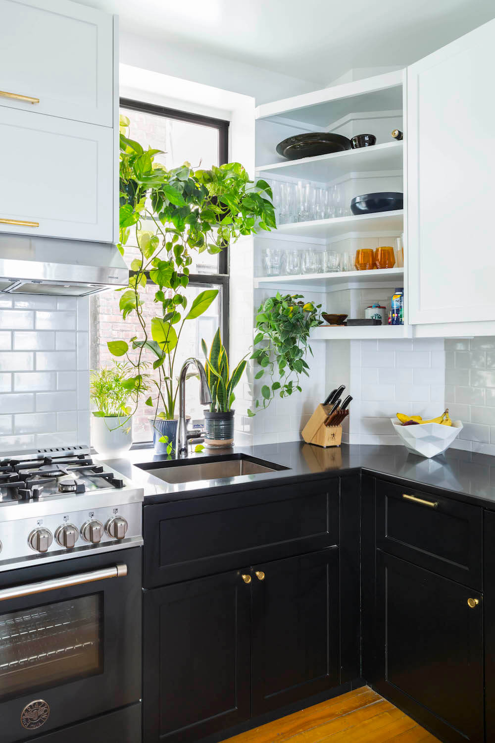 Black cabinets and counter with white backsplash and upper cabinets