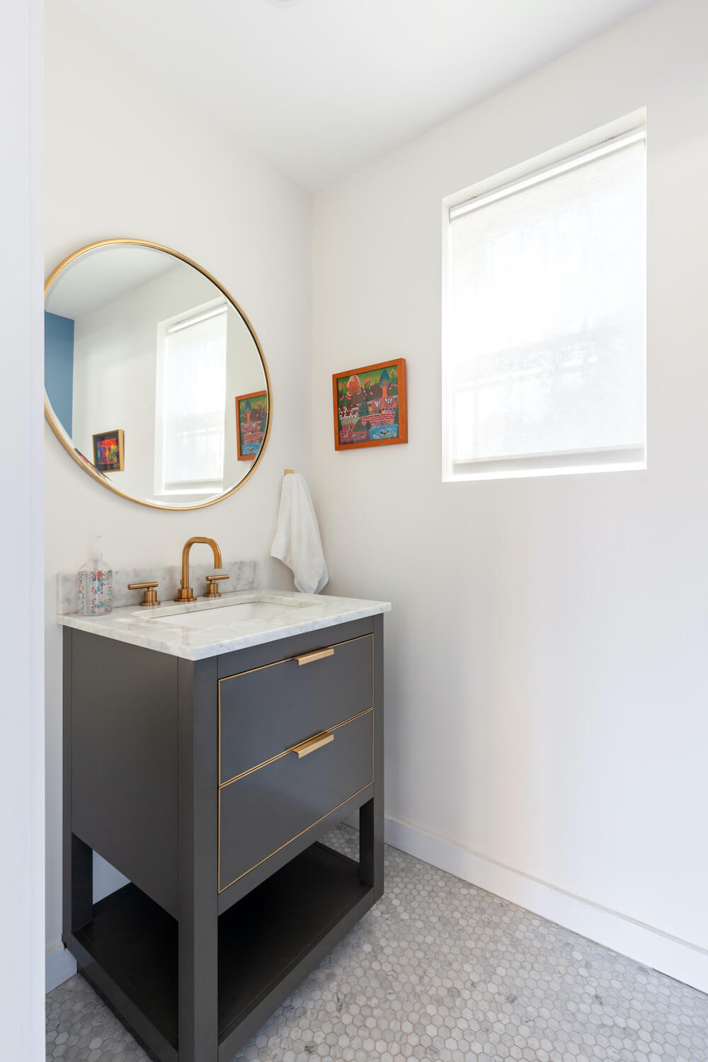 bathroom addition with dark gray vanity, gold hardware, round mirror