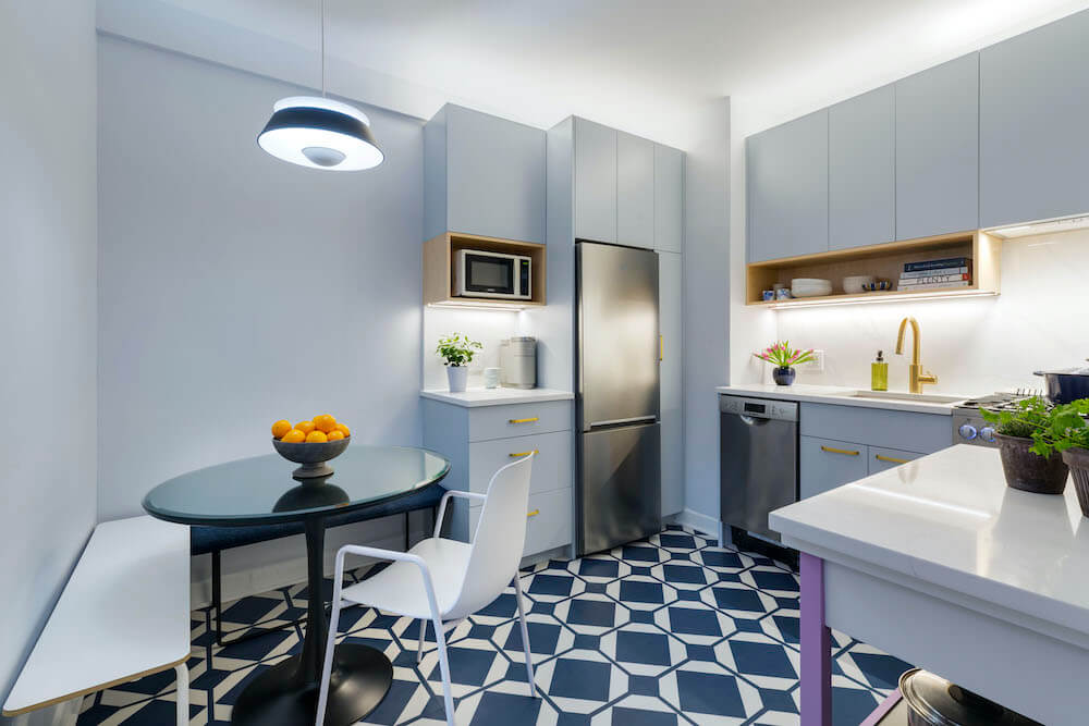 Image of a kitchen with patterned floor tile and blue cabinets