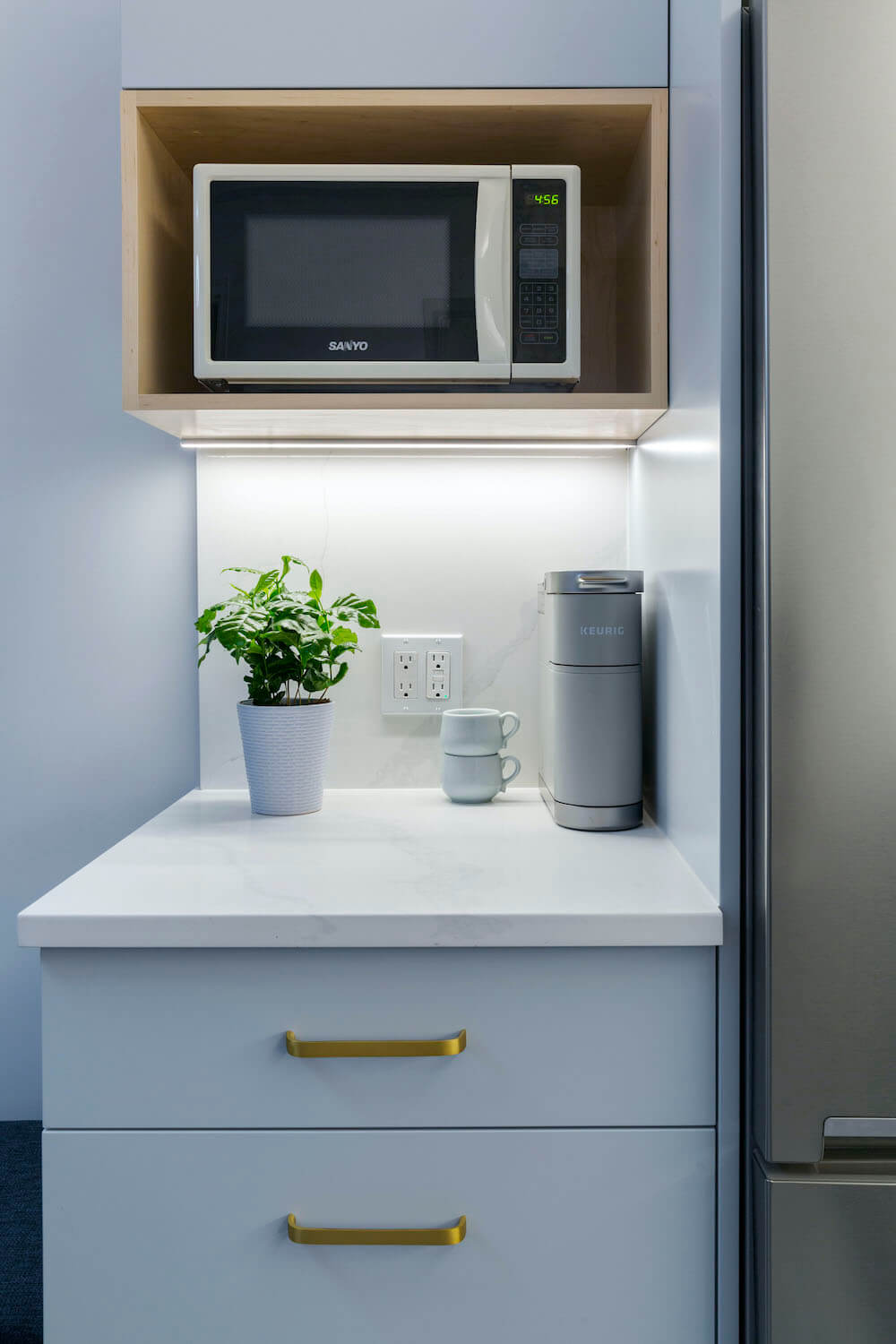 Image of a renovated kitchen with quartz countertop and microwave storage