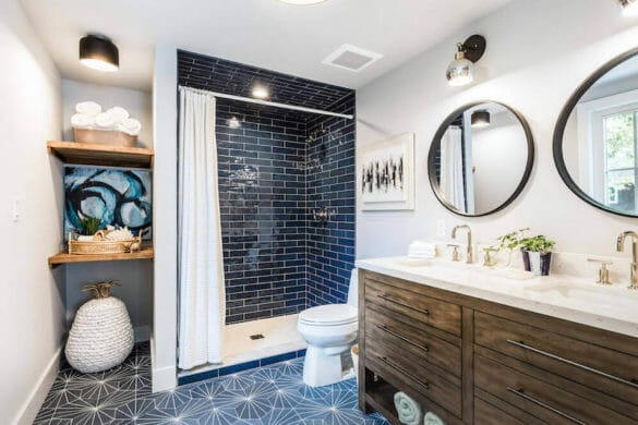 bathroom with black shower tile and double sink vanity