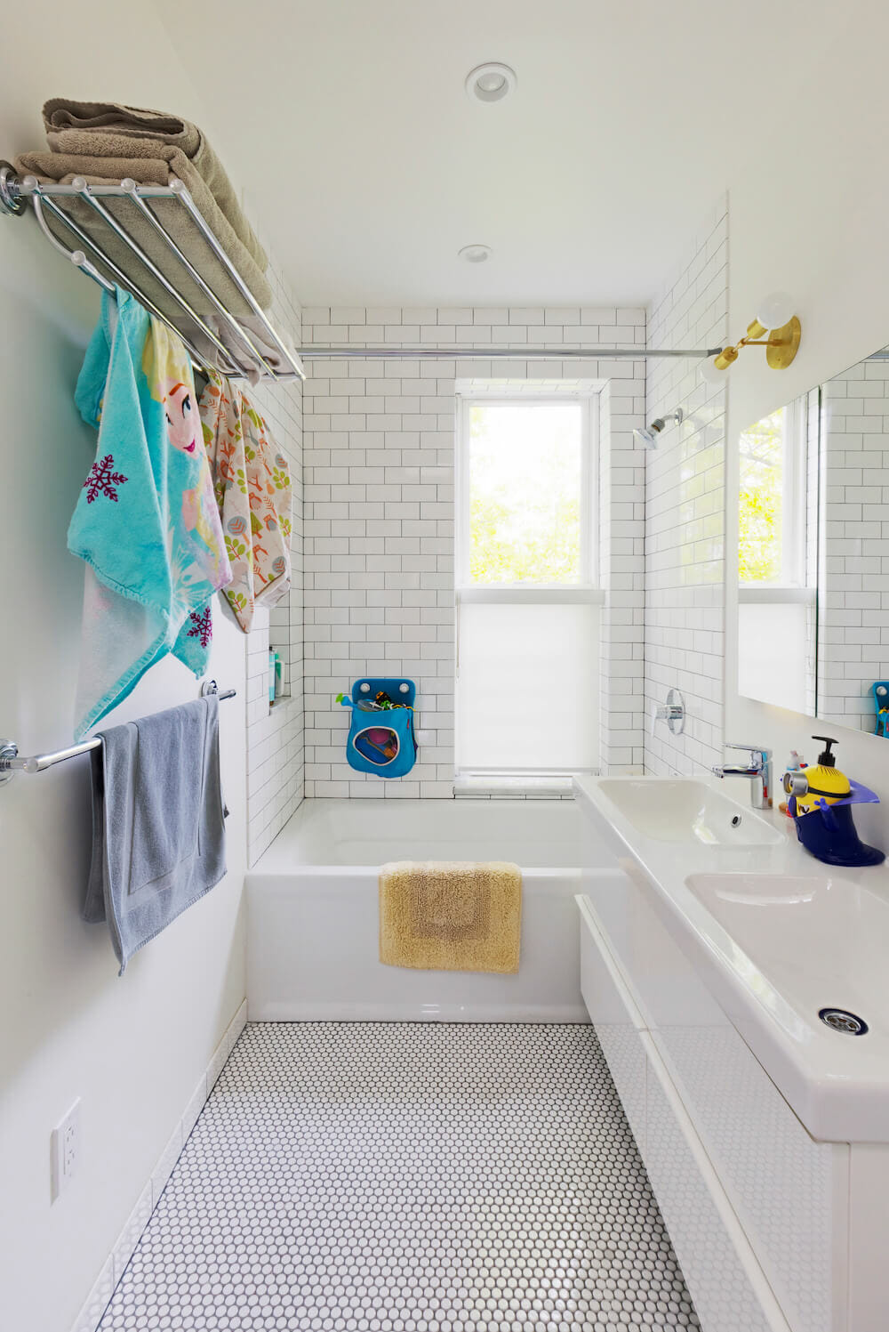 White double sink in bathroom with white bathtub and towel bar storage after renovation