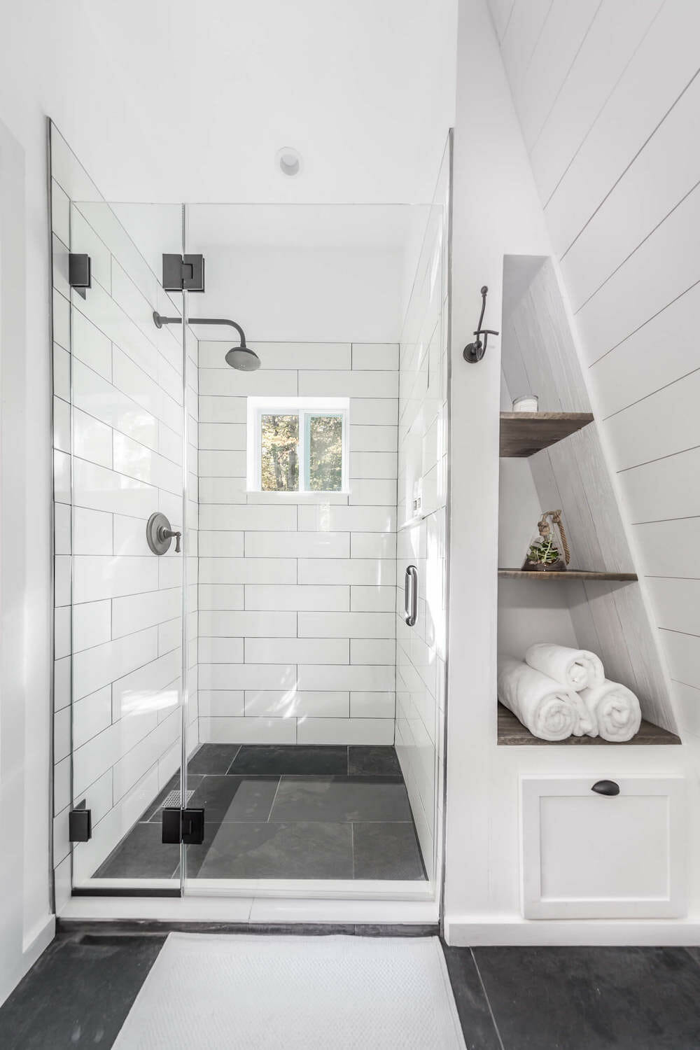Walk in shower beside triangular storage nook with shiplap wall Riverhead bathroom remodel
