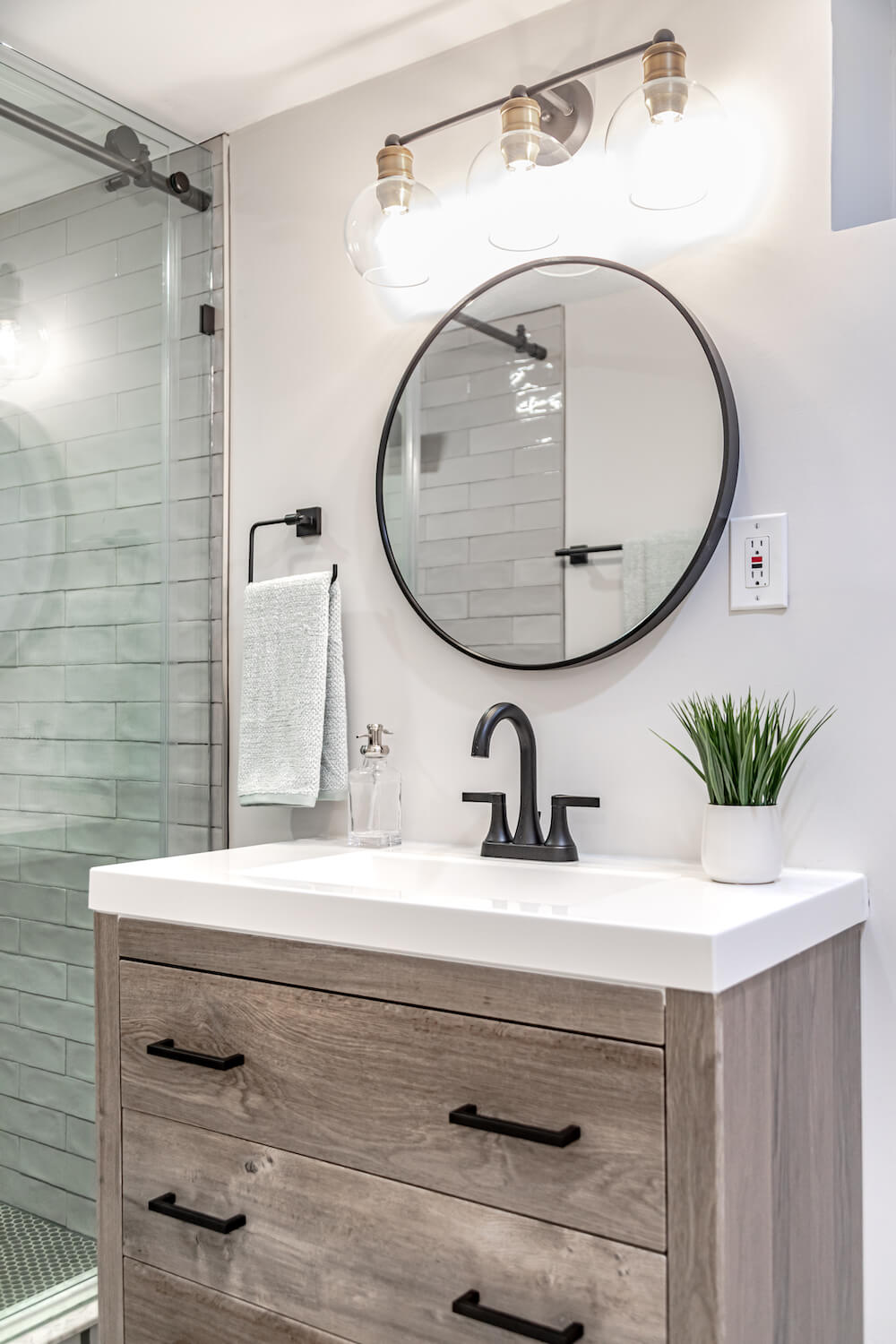 Image of wooden bathroom vanity with circular mirror 
