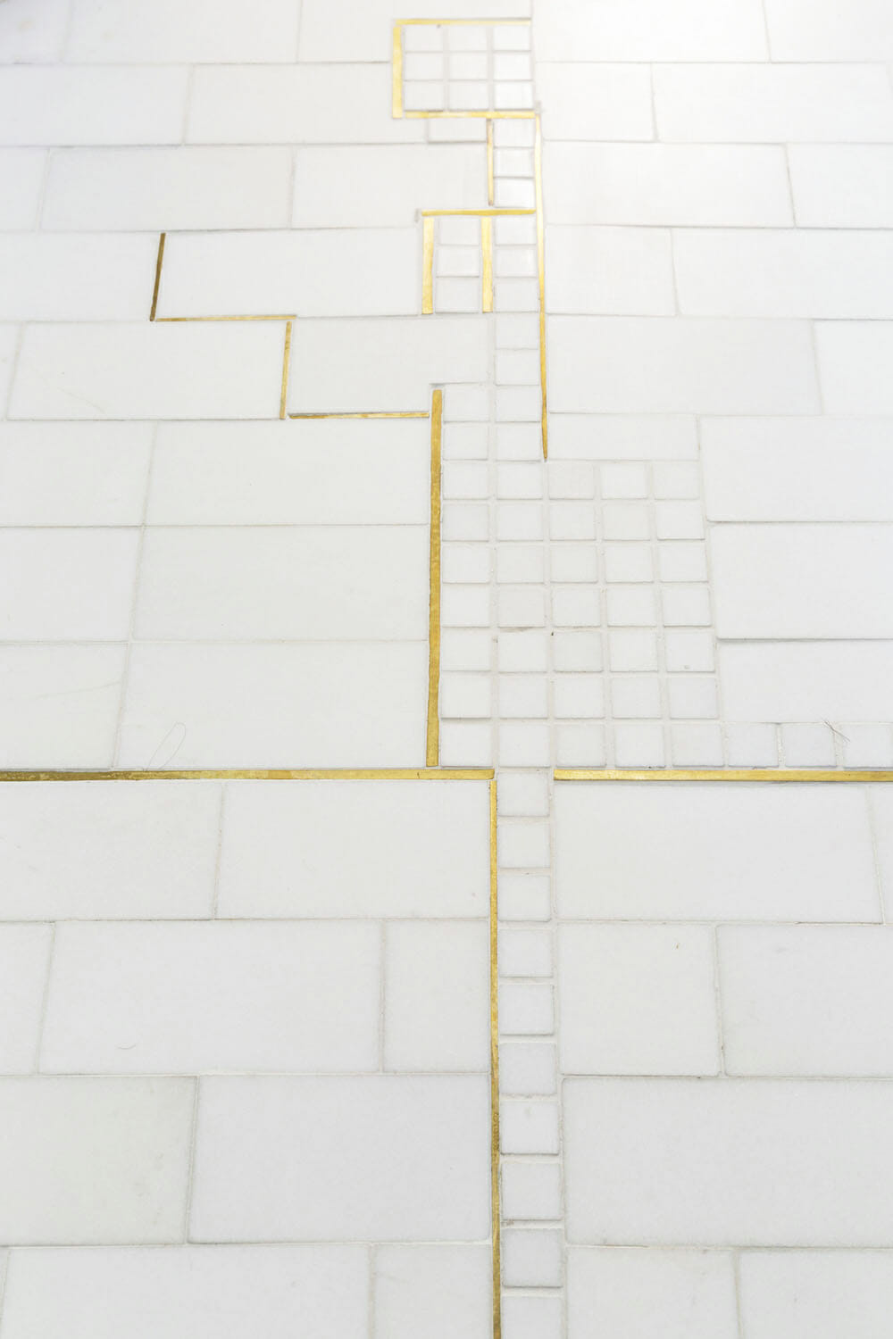 subway and small square tiles designed together with brass inlay after renovation
