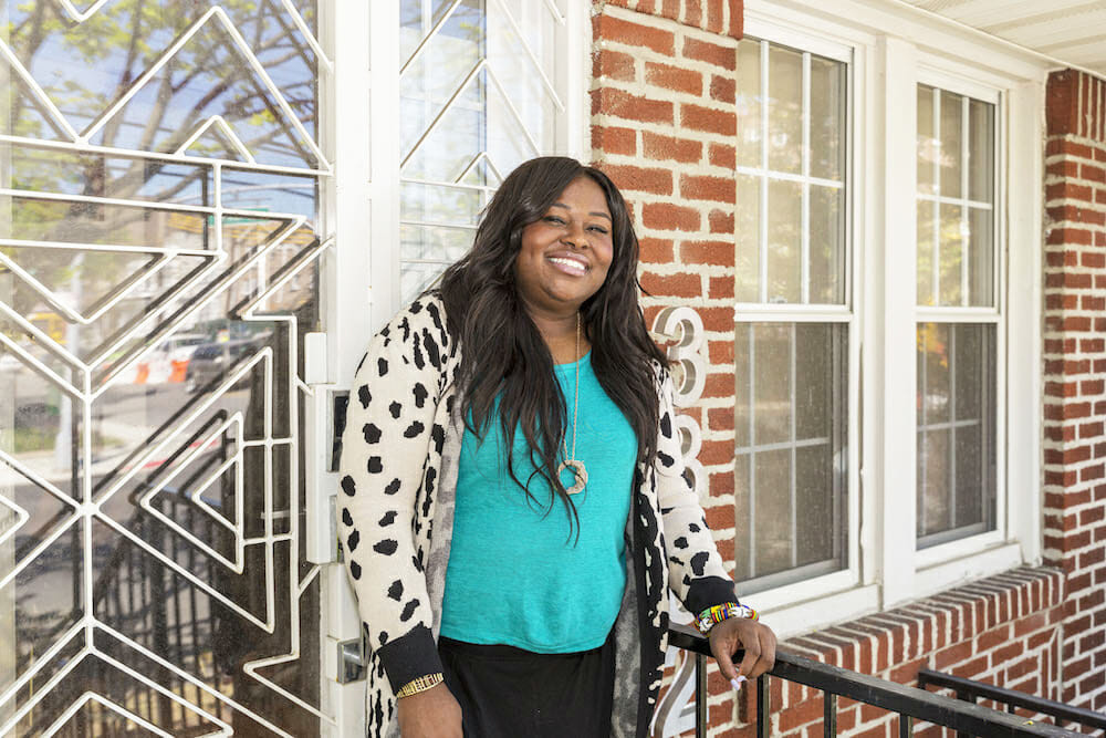 allyson standing outside the entrance door and brick exterior after renovation