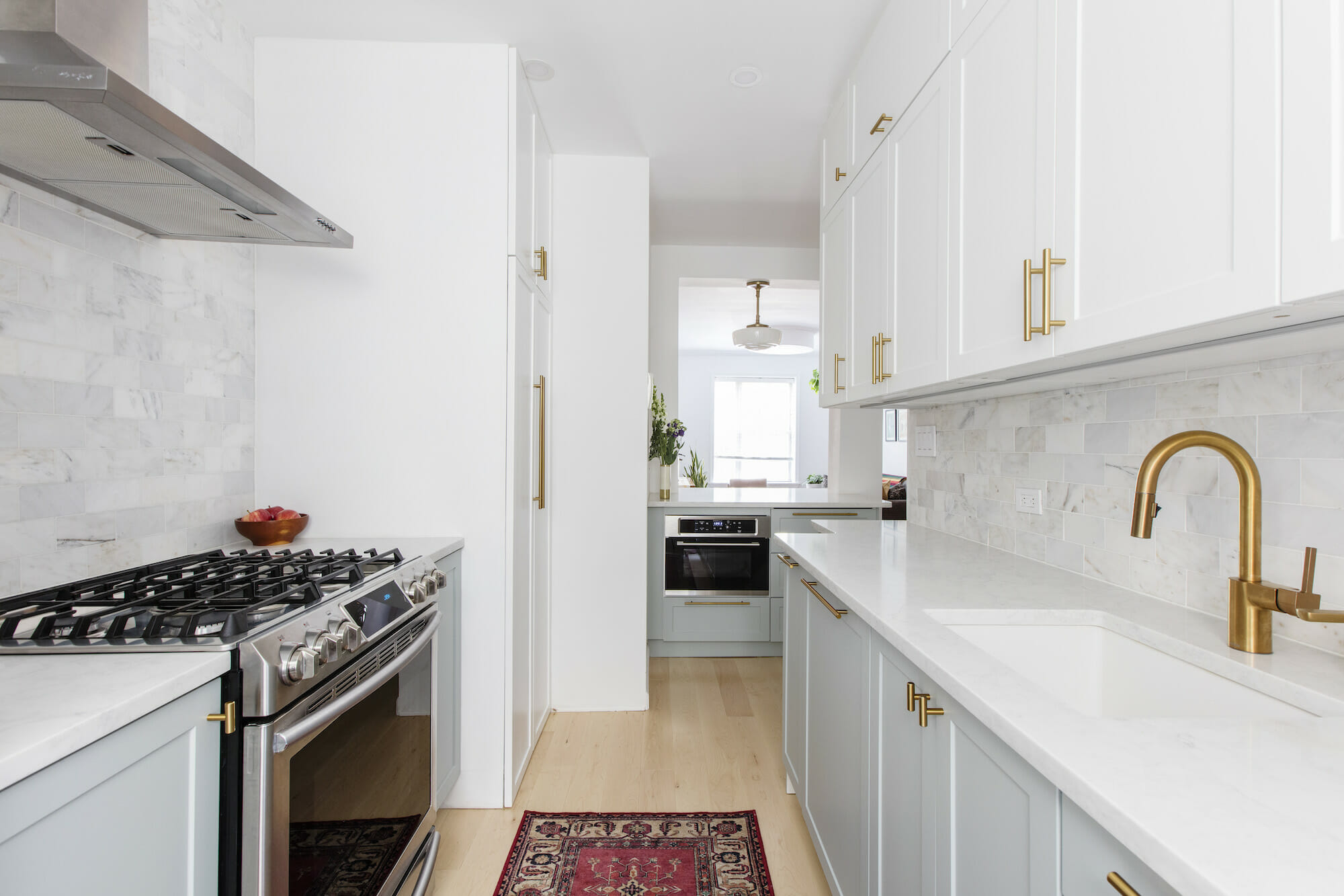 Image of a galley kitchen with white and agave cabinets with gold fixtures
